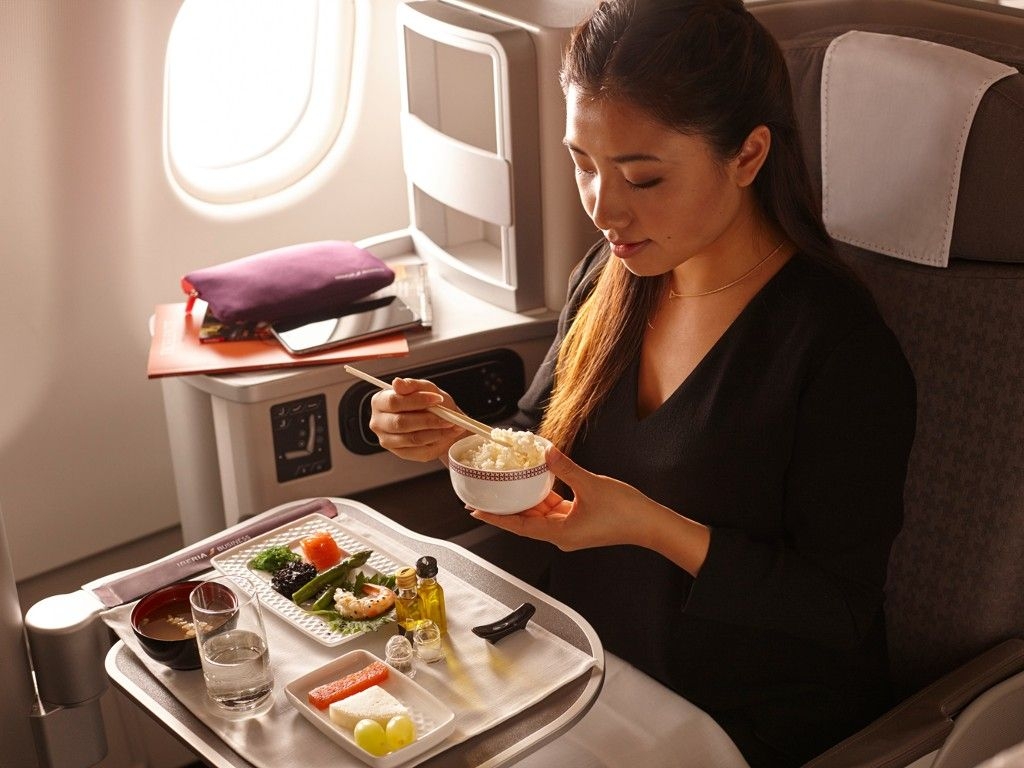 woman eating in Iberia business class seat. 