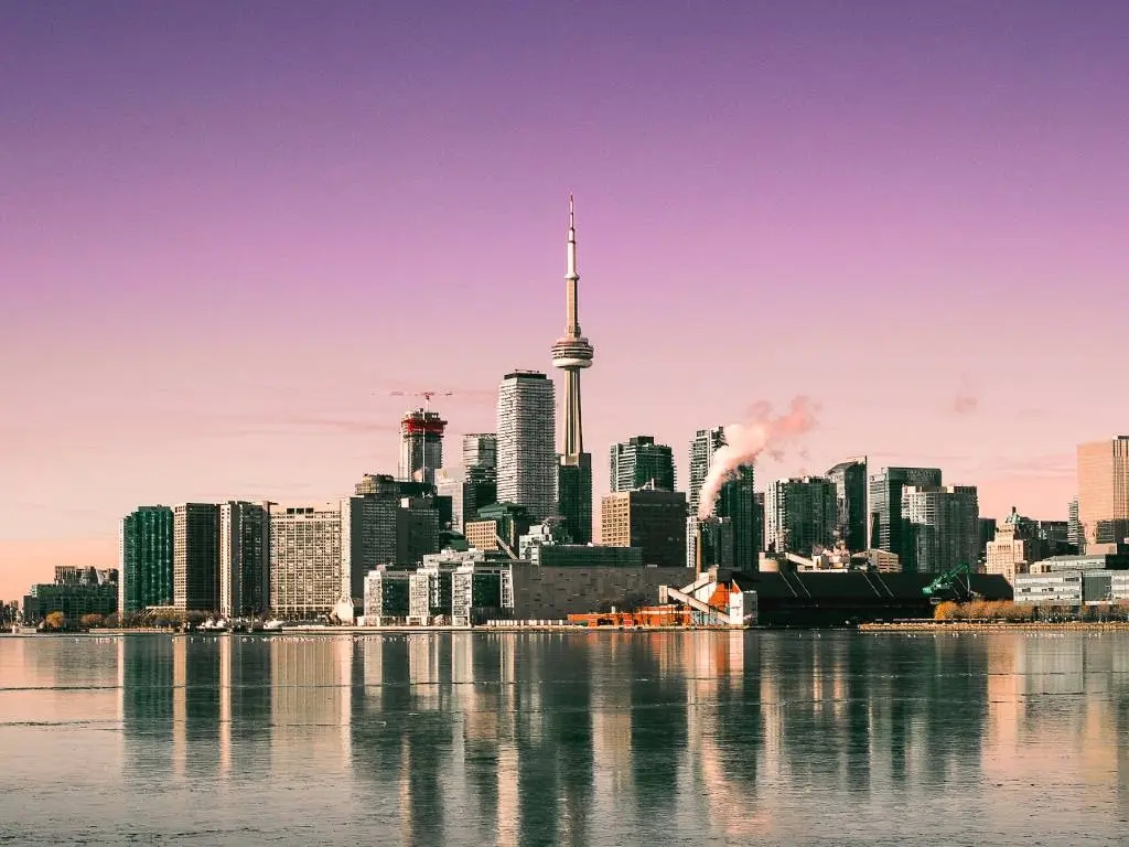 The Toronto skyline is reflected in a body of water