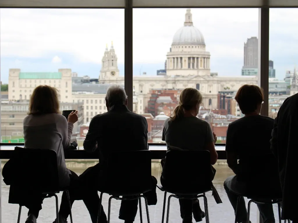 People sitting at a cafe with a view of London behind them