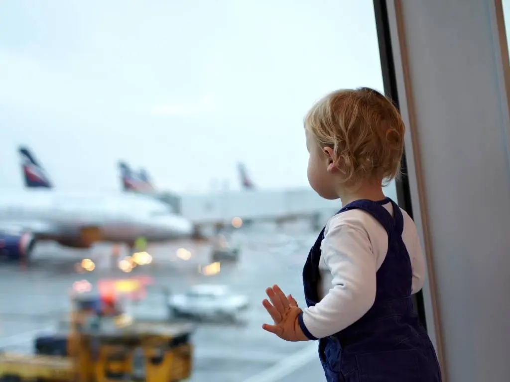 baby watching planes out the window at airport