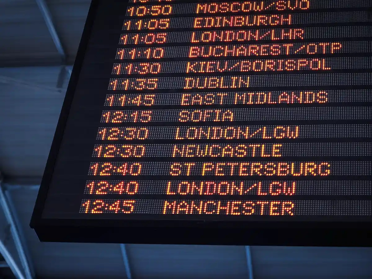 A departures board at an airport displaying the times and destinations for upcoming flights