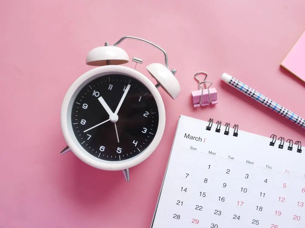 image of a calendar next to an alarm clock.