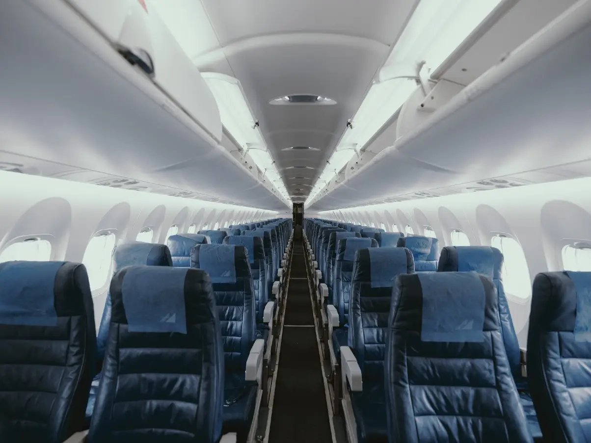 Looking down length of airplane from the interior with view of rows of seats.
