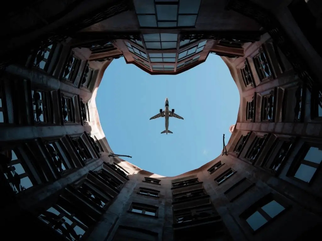 looking up at plane between buildings