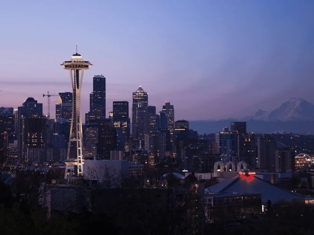 Seattle skyline with Space Needle and mountains.