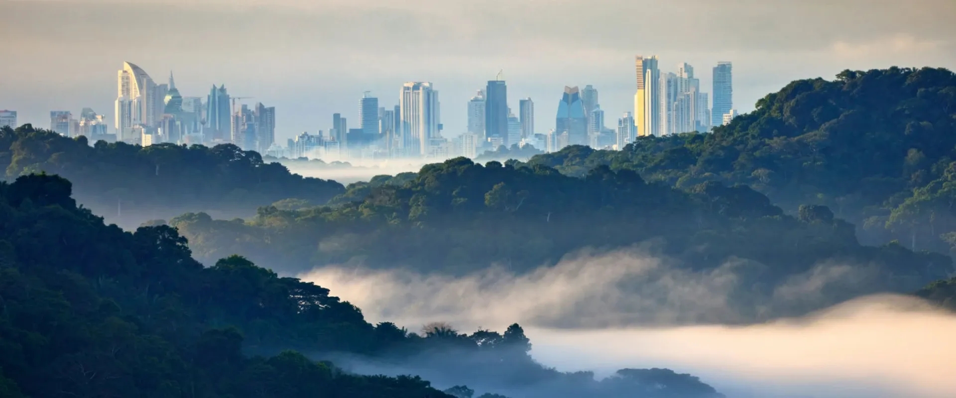 Panama City, Panama, skyline behind rolling hills and a dense fog