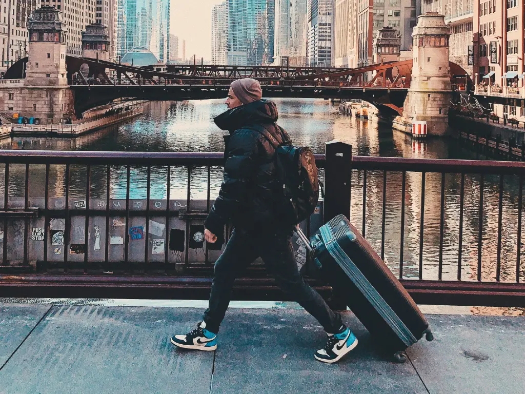 person walking through Chicago with luggage
