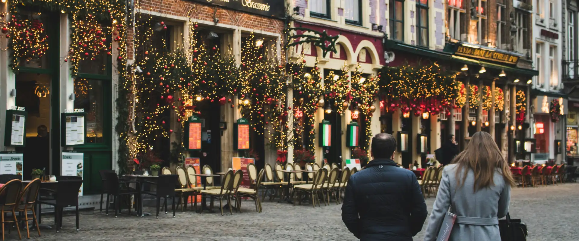 Couple walks into Christmas-lit stores during the holiday season