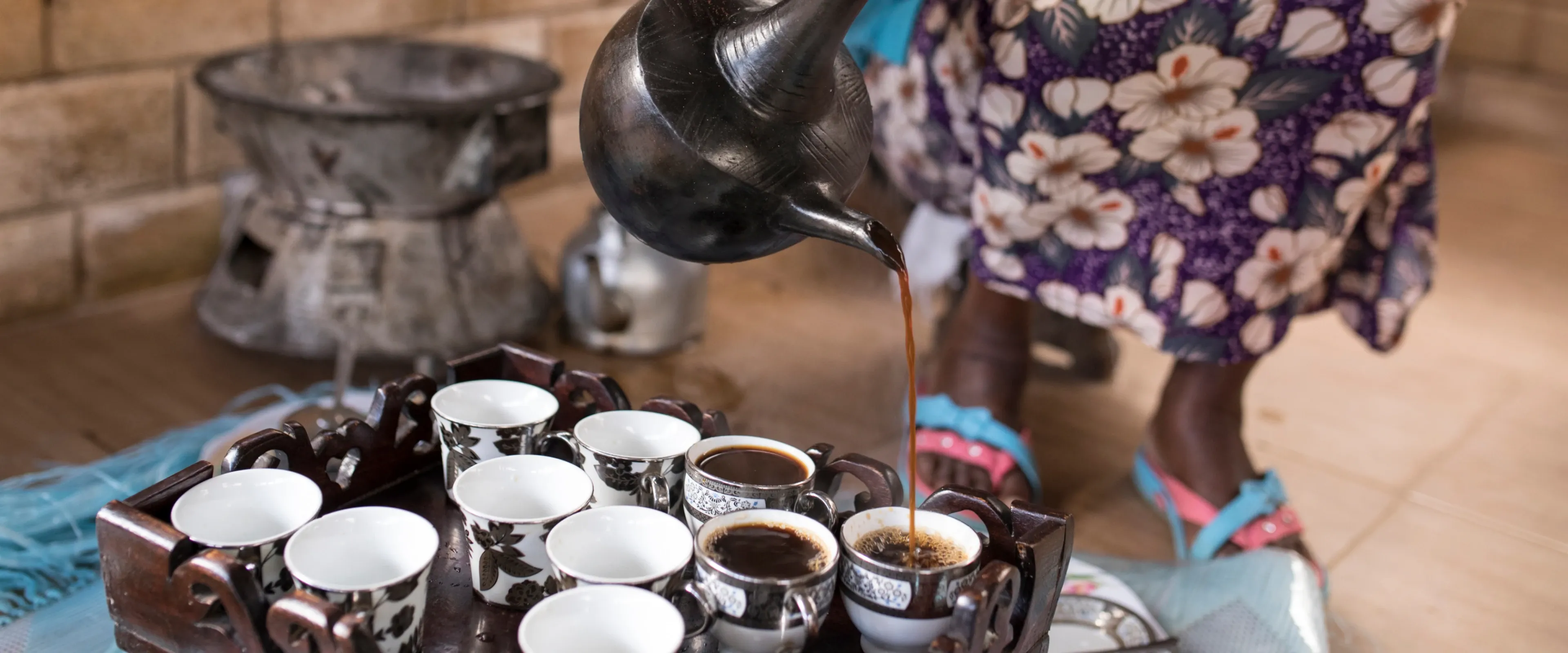 A woman pours coffee during a buna ceremony in Ethiopia