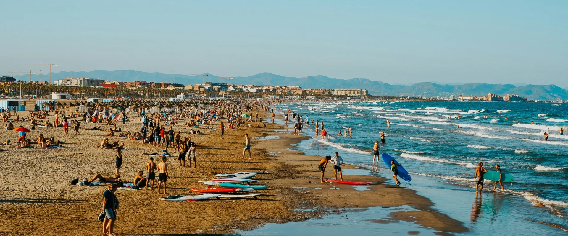 People sit on the beach in Valencia