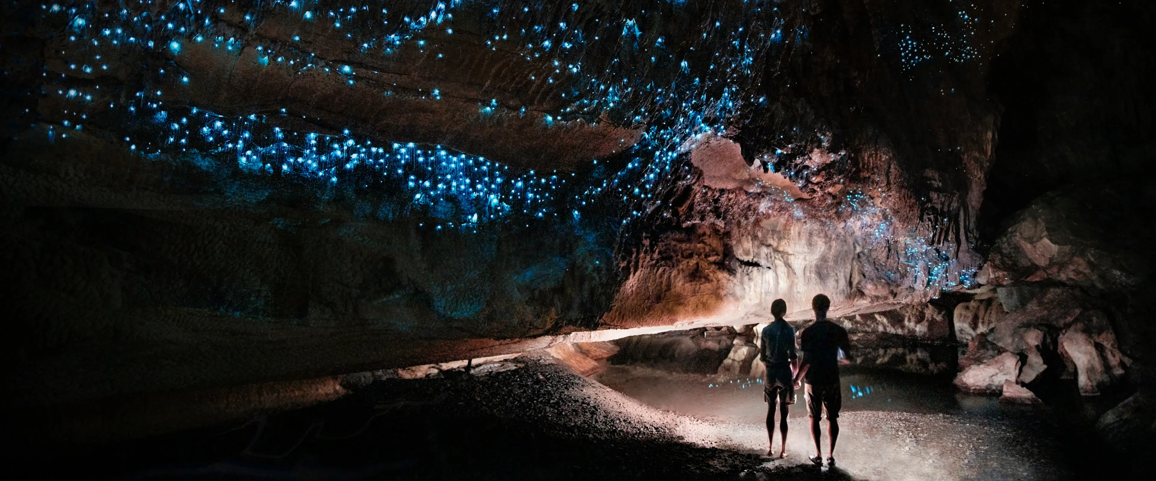 People walk through the Waitomo Glowworm Caves in New Zealand